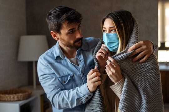 Couple wrapped tightly in blankets endures a cold home caused by unpaid bills and the energy crisis