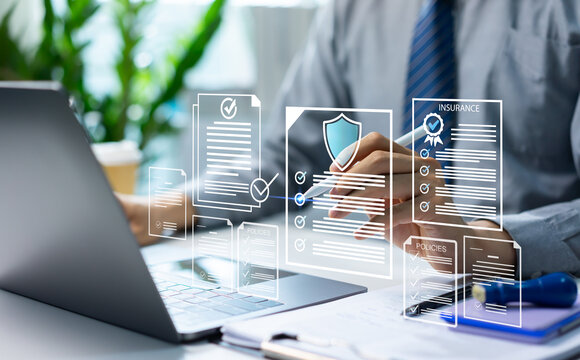 Businessman reviewing digital insurance policies and compliance documents on laptop and tablet. Risk management data security policy protection, regulatory compliance and insurance technology concept.