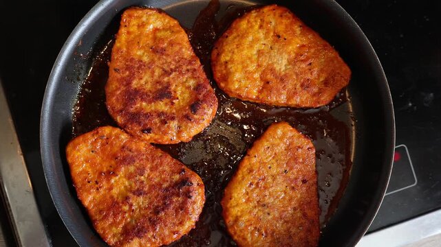 Golden brown schnitzel frying in hot oil