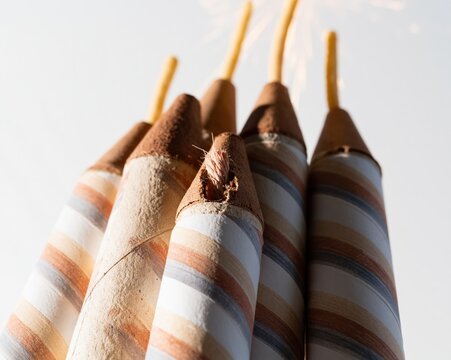 Cluster of firework bottle rockets with decorative stripes standing upright against a bright background for patriotic celebration marketing, holiday events and product styling