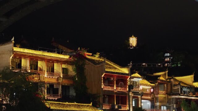 Night walking past lantern lit heritage houses, ornate roofs and balcony facades adorned with string lights, warm glow spilling onto narrow alley and cobblestone market, festive ambiance evokes