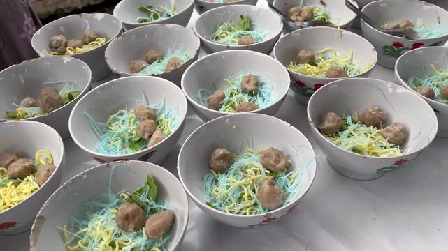 Rows of traditional Indonesian meatball soup bakso served in ceramic bowls