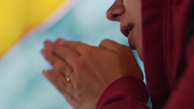 Night walking closeup hands clasping hoodie, person warming hands under street glow, soft bokeh, cinematic shallow depth, silent urban commute, reflective mood, visible ring on finger, candid night