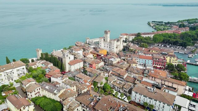 Sirmione old town with Scaliger Castle on Lake Garda. Dense rooftops, narrow streets and lakeside buildings in historic Italian travel destination