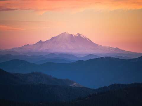 Layered mountain ranges with Mount Rainier at sunset