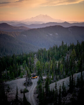 Yellow UTV driving on a forest mountain trail