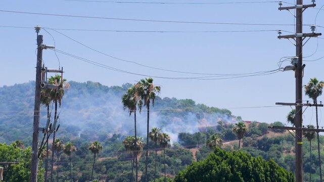 Slow motion shot of Los Angeles Fire Department responding to wildfire with aerial unit dropping water 