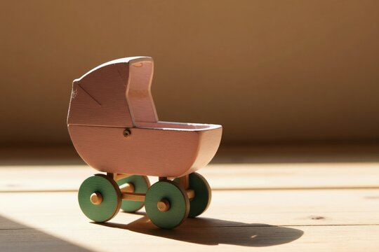 Empty pink toy pram on wooden floor. Sunlight casts shadow. Symbolizes infertility, loneliness, or lost childhood dreams. Represents childless future or sorrow.