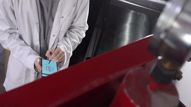 Close up of hands drawing blueprint sketch of hydraulic press on smartphone with stylus