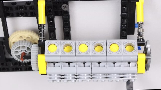 Close up of Lego Technic plastic model of an inline six cylinder engine with gears and pistons