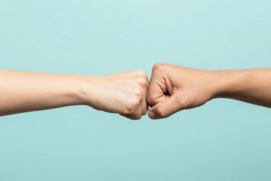 Close up shot of couple two male friends men together hold hands folded fist bump gesture isolated on pastel plain light blue cyan color background studio portrait. Friendship business greet concept.