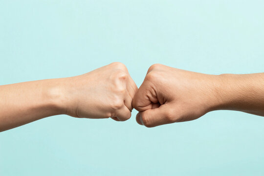 Close up shot of couple two male friends men together hold hands folded fist bump gesture isolated on pastel plain light blue cyan color background studio portrait. Friendship business greet concept.