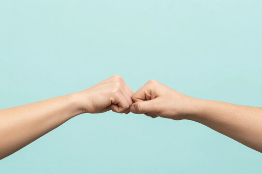 Close up shot of couple two male friends men together hold hands folded fist bump gesture isolated on pastel plain light blue cyan color background studio portrait. Friendship business greet concept.