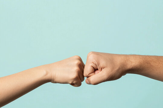 Close up shot of couple two male friends men together hold hands folded fist bump gesture isolated on pastel plain light blue cyan color background studio portrait. Friendship business greet concept.