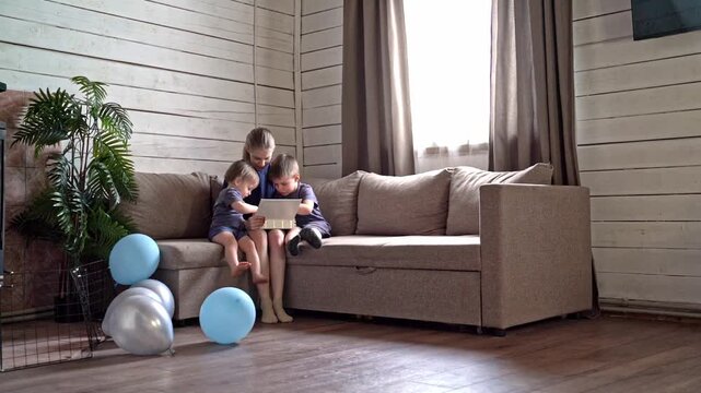 Family learning together. Children explore story with smiles. Siblings share joyful reading on comfy sofa. Relaxed family shares educational moments with balloons and gentle lighting