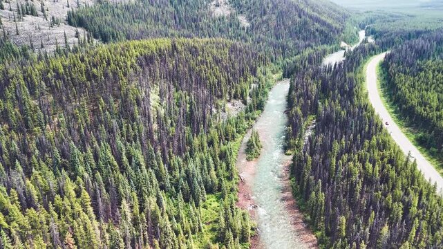 Jasper aerial cityscape with Athabasca River surrounded by mountains and green summer scenery