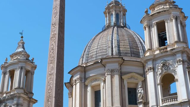 Piazza navona obelisk and church of sant'agnese in agone in rome. Vertical camera movement revealing the famous fountain of the four rivers obelisk and the baroque facade of the church of sant'agnese