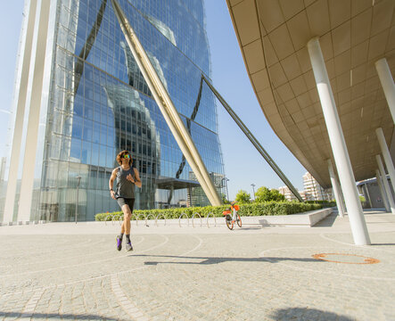 Urban runner enjoys a sunny day near modern architecture in the city
