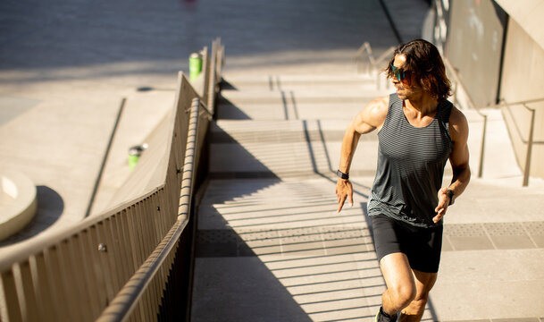 Person runs up stairs in a city park area during a sunny day in the afternoon