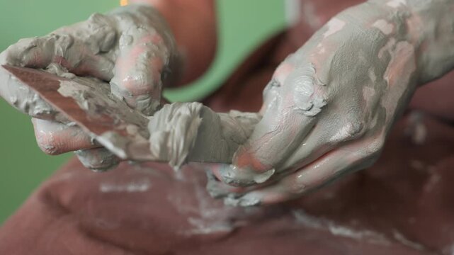 Pottery hands finishing. Ceramic shaping process complete. Expert hands smooth and refine clay vessel. Detailed view of craftsmen refining and polishing pottery rim in studio setting