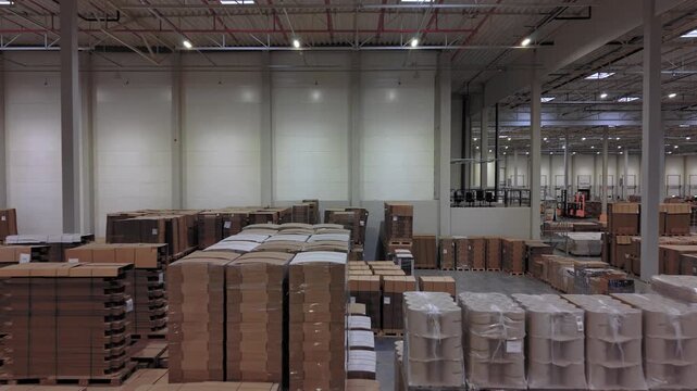 Top-down aerial view inside a large warehouse, showing massive storage racks fully stocked with inventory. Overhead perspective illustrating industrial logistics and supply chain management