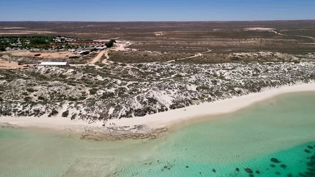 Bright sunny day over Coral Bay captured from above with sparkling water and coastal scenery