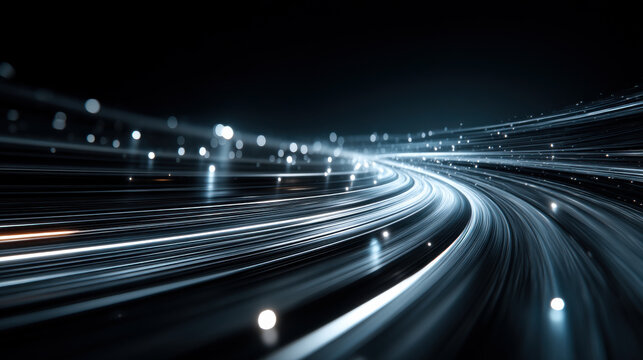 Lines of light flow smoothly in a dark background. The lights travel fast, creating a feeling of movement. The scene captures an abstract representation of light in motion.