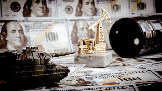 Military tank, oil rig, barrel rest on dollar bills
