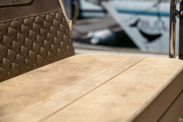 Naklejka premium Close-up of a boat's upholstered seating area with yachts in the background