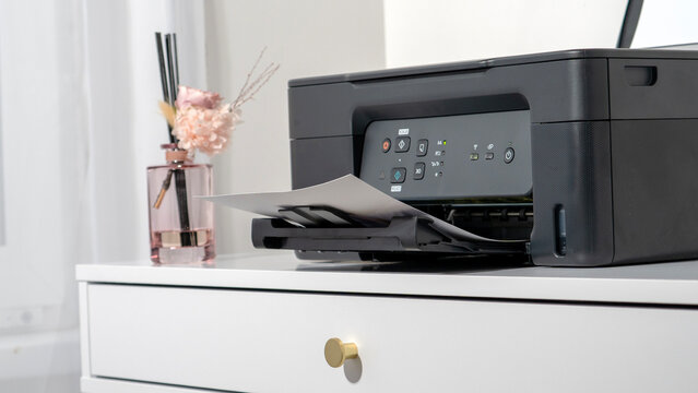 Modern printer sits on clean white drawer