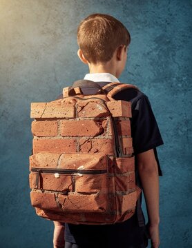 Brick backpack on a young student boy seen from behind for mental health awareness, academic pressure concepts and school stress campaigns with copy space