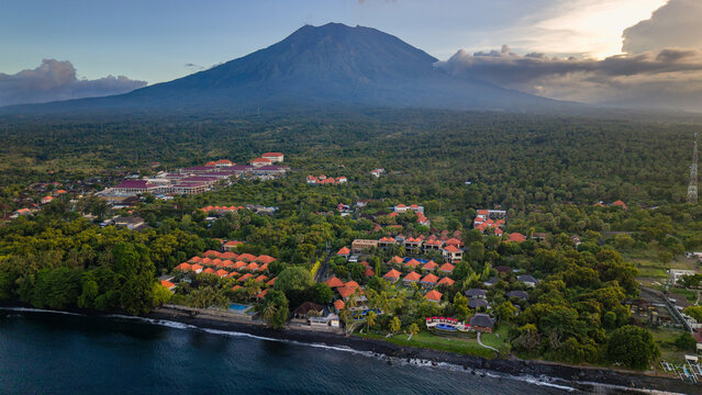 Scenic tropical coast with volcanic mountain backdrop under a cloudy sky