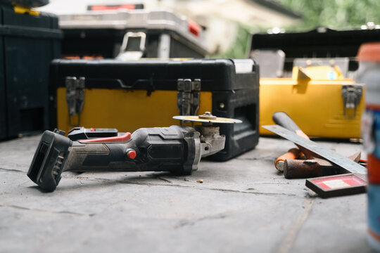 Cordless Power Tool and Yellow Toolboxes on Concrete Floor at Construction Site