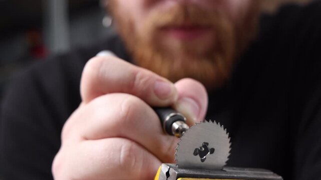 Close up of a focused technician using an engraving pen tool for detailed workshop modification