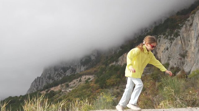 Acrobatics cartwheel girl, young female dancing happily on foggy mountain cliff road enjoying nature and freedom.