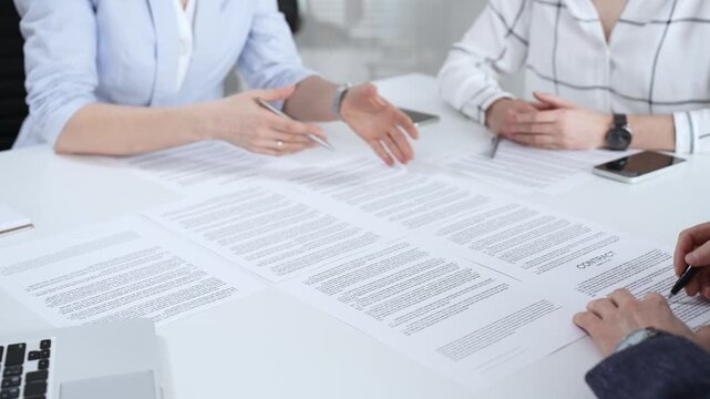 Business people discussing contract terms, outlining agreements, and reviewing legal documents during a corporate meeting, preparing for a significant partnership signing and negotiation