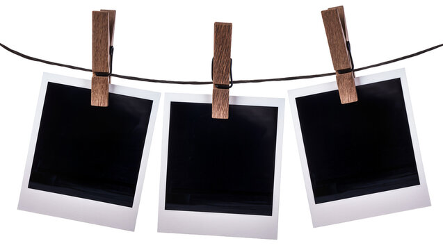 Three empty instant photo frames held by wooden clothespins on a string, isolated on transparent background
