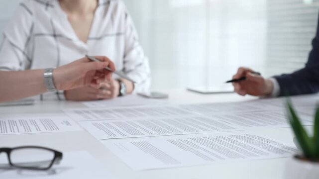 Business partners discussing financial contracts, reviewing legal documentation, and making important decisions at a corporate meeting or during a client consultation