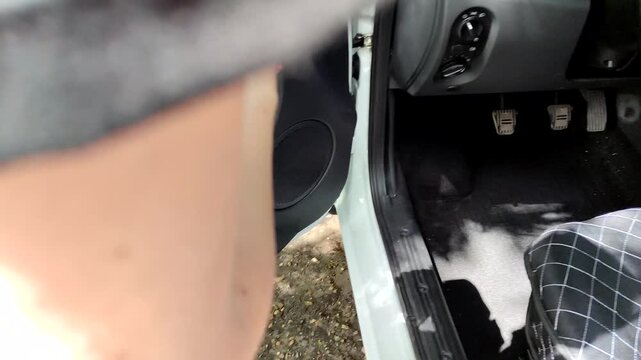 Woman washing car, wiping door panel with cloth