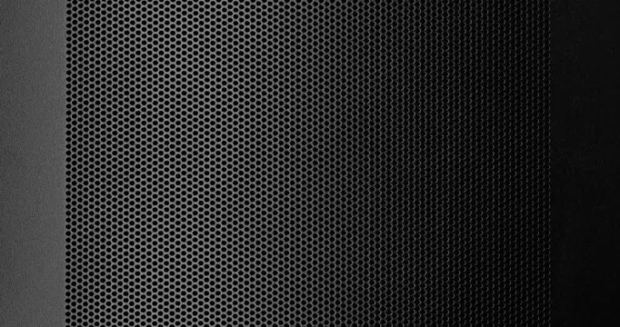 Perforated Metal Surface. A black perforated surface with a repeating pattern of holes creates a textured, industrial look.	