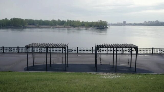 Empty swings on improved Yenisei River embankment early morning after rain in Krasnoyarsk Russia