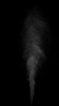 Hot Steam Plume Rising on Black. Vertical slow-motion of hot steam powerfully rising from below, forming a tall turbulent column that expands, gradually dissipates into fine sparkling particles.