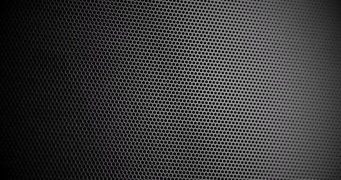 Perforated Metal Mesh. Smooth slow movement across extreme close-up of dark perforated metal grid with dramatic side lighting.