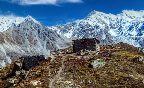A breathtaking arrival scene at Nanga Parbat Base Camp, with trekkers celebrating beneath the colossal snow-covered peak of Nanga Parbat under a crystal-clear blue sky