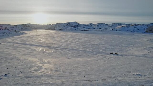 Arctic Journey Adventure. Explorers Trekking Across Extensive Snow Plains With Sleds snowmobile