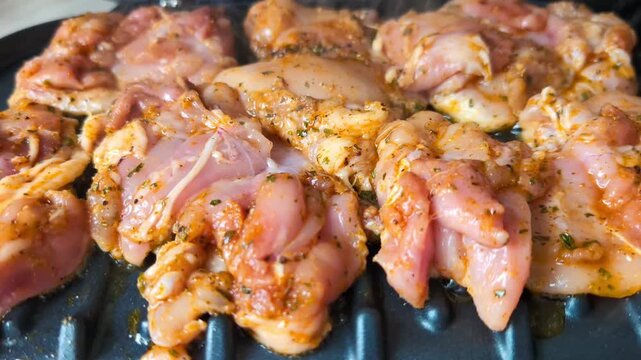 Healthy lifestyle concept showing seasoned poultry being cooked on a modern panini style grill, emphasizing lean protein, home cooking, and nutritious