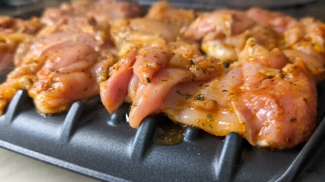 Healthy lifestyle concept showing seasoned poultry being cooked on a modern panini style grill, emphasizing lean protein, home cooking, and nutritious