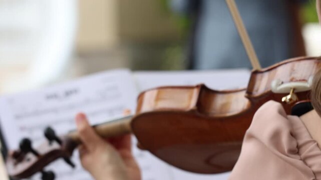 Extreme close up of a musician hand playing violin strings during a live concert performance