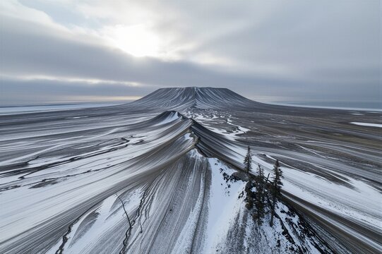 The central volcanic mountain of Askja caldera in Iceland stands serene amidst snow-covered slopes and vast frozen terrain.