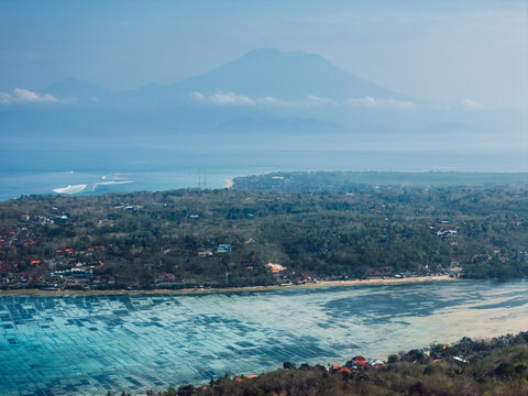 Volcanic island landscape with coastline and volcano mountain in tropical haze